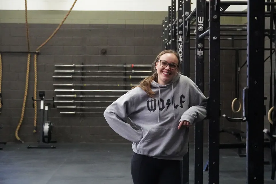 Smiling member leaning on the rig at Whit Fitness
